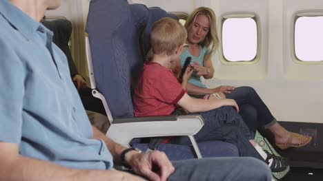 Family-using-cellphone-on-plane