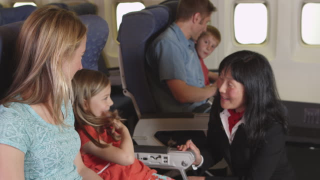 Flight-attendant-speaking-to-child-on-plane