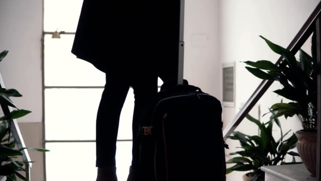 Close-up-view-of-young-businesswoman-with-suitcase.-Traveler-girl-comes-downstairs-on-ladder-with-baggage