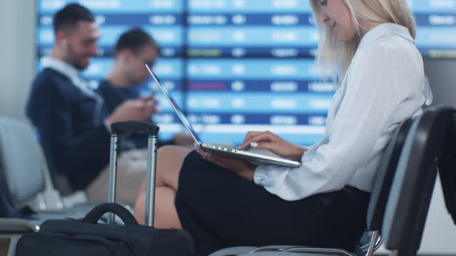 Attraktive-Adult-Business-Frau-mit-Laptop-beim-Boarding-warten-am-Abflug-Lounge-am-Flughafen.