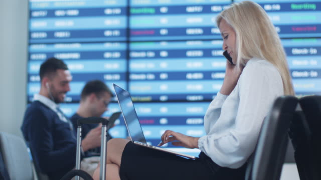 Attraktive-Adult-Business-Frau-am-Telefon-sprechen-während-der-Wartezeit-Boarding-am-Abflug-Lounge-am-Flughafen.