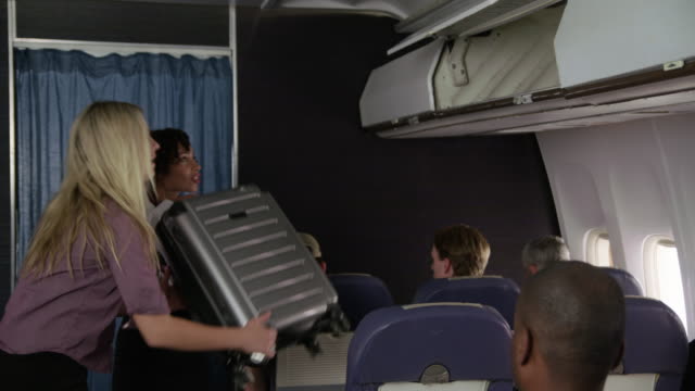 Flight-Attendant-Passagiere-mit-Gepäck-zu-helfen