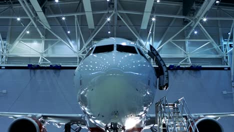 Down-Up-Shot-of-a-Brand-New-Airplane-Standing-in-a-Aircraft-Maintenance-Hangar.-Plane's-Door-is-Open-and-Ladder-Stands-Beside-it.