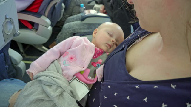 A-Woman-Holding-her-Child-on-a-Plane
