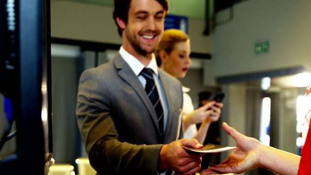 Businessman-showing-his-boarding-pass-at-the-check-in-counter