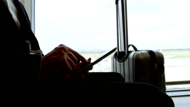 Geschäftsmann-mit-digital-Tablette-am-Flughafen