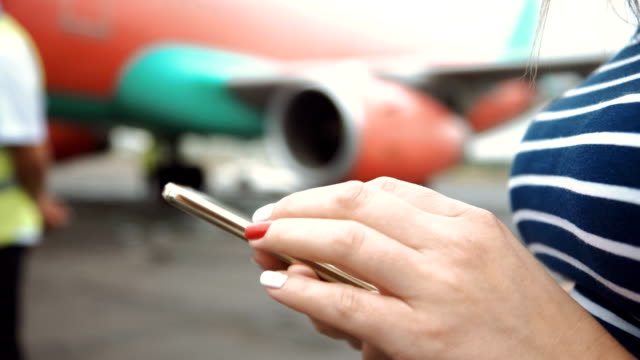 Woman-browsing-smartphone-at-airplane