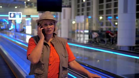 Eine-Frau-im-Flughafen-und-am-Telefon-zu-sprechen.