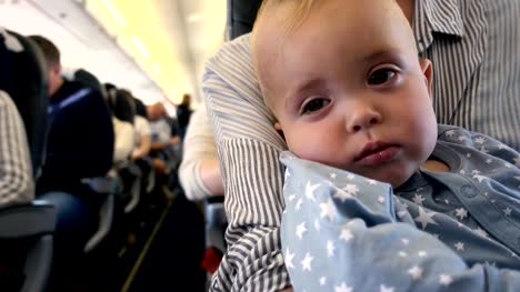 Kid-falls-asleep-in-the-plane-at-mom's-hands