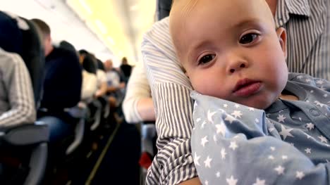 Tired-toddler-in-the-plane-at-the-mother's-lap