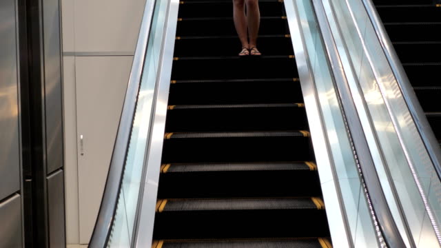 Pretty-Young-Brunette-Woman-Coming-Down-The-Escalator