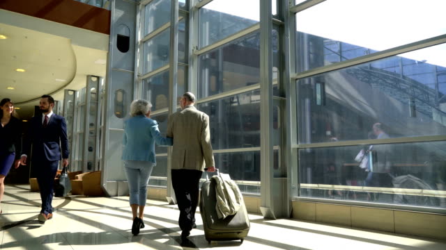 Two-seniors-walking-with-suitcase