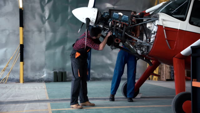 Two-mechanics-working-on-a-small-aircraft
