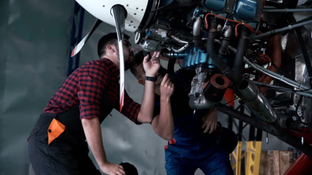 Two-mechanics-working-on-a-small-aircraft