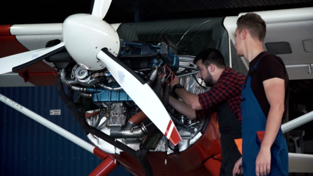 Zwei-Mechaniker-arbeitet-an-einem-kleinen-Flugzeug