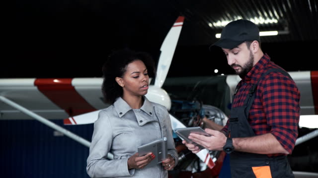 Pilot-and-mechanic-discussing-aircraft-repairs