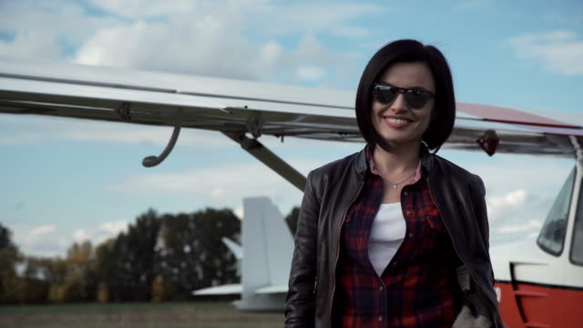 Attractive-friendly-woman-in-front-of-a-plane