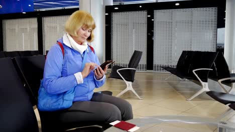 Die-Frau-am-Flughafen-warten-auf-Abfahrt,-und-schrieb-auf-dem-Smartphone.