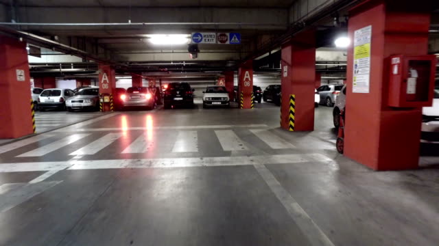 Movimiento-pov-en-el-estacionamiento-subterráneo-en-el-edificio-grande,-centro-comercial