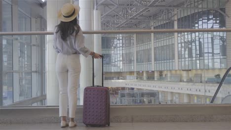 Junge-Frau-mit-Gepäck-im-Flughafen-zu-Fuß-mit-ihrem-Gepäck.-Flugreisenden-in-einer-Flughafenlounge-wartet-auf-Flug-Flugzeug
