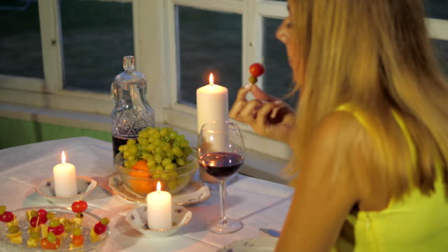 Mujer-cenando-en-el-restaurante-una-mesa-romántica-con-vino-de-fruta,-comer-canapés