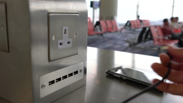 Traveler-charging-mobile-phone-battery-at-free-service-charging-station-at-International-Airport.