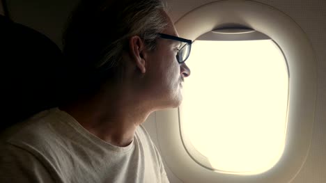 man-looking-out-of-airplane-window