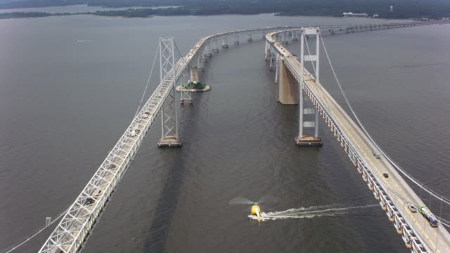 Aerial-shot-of-helicopter-flying-by-the-Chesapeake-Bay-Bridge.