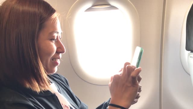 Felicidad-de-la-chica-con-smartphone-y-sonriendo-en-el-avión.