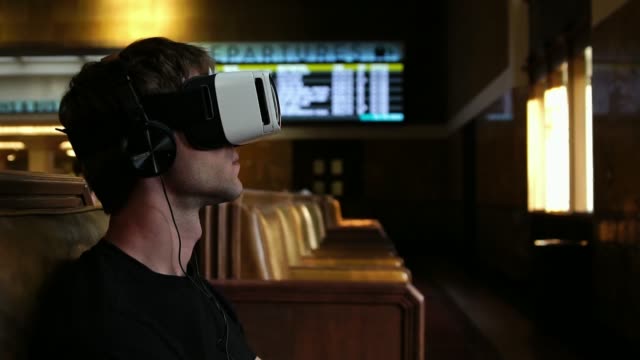 Young-man-wearing-virtual-reality-headset-watching-360-video-in-train-union-station