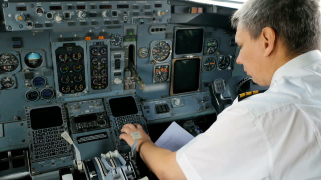 Captain-of-airplane-prepares-documents-before-flight-sitting-in-cockpit