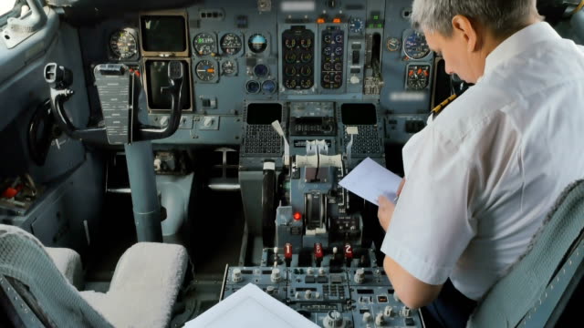 Capitán-de-avión-se-prepara-para-el-vuelo-y-llena-documentos