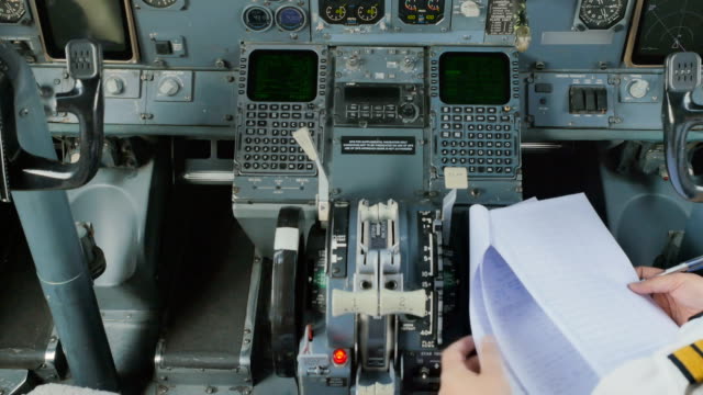 Pilot-sitzt-im-Cockpit-und-prüft-Dokumente-vor-Flug