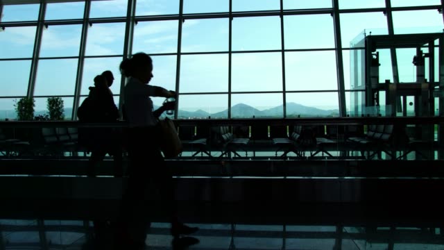 Silueta-de-pasajeros-empresario-caminando-en-el-edificio-del-aeropuerto-ocupado