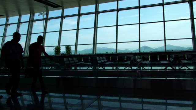 Silhouette-der-Geschäftsmann-Passagiere-zu-Fuß-in-der-geschäftigen-Flughafen-Gebäude