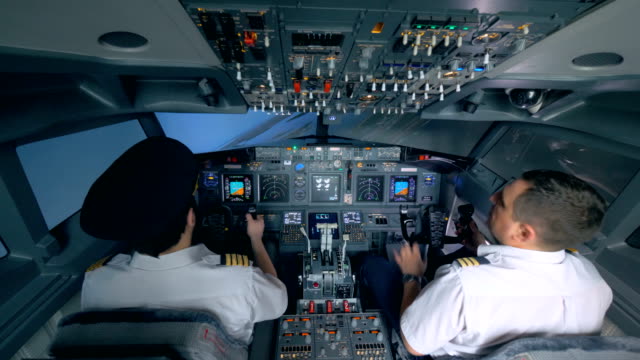 Two-pilots-turn-the-plane-in-a-flight-simulator.