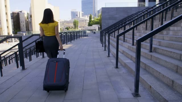 Back-view-asian-business-woman-with-suitcase