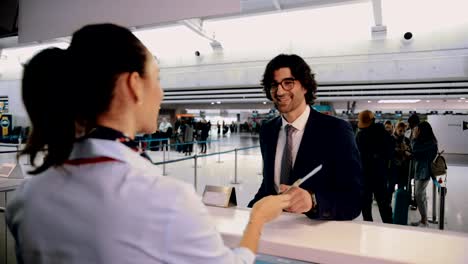 Young-businessman-doing-check-in-at-airport-before-international-business-travel