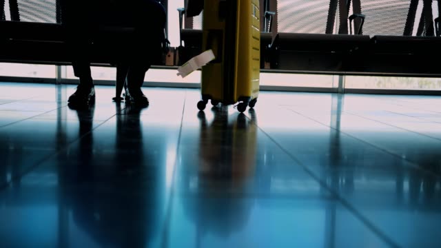 Close-up-of-businessman-with-luggage-waiting-to-board-on-airplane