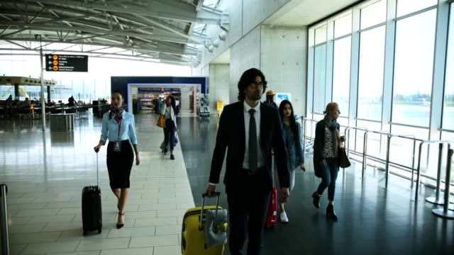 Multi-ethnic-travelers-with-suitcases-walking-at-international-airport