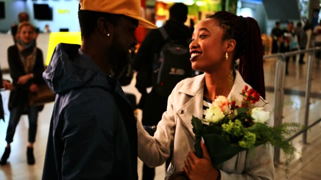 Young-emotional-couple-embracing-at-airport-after-flight-arrival