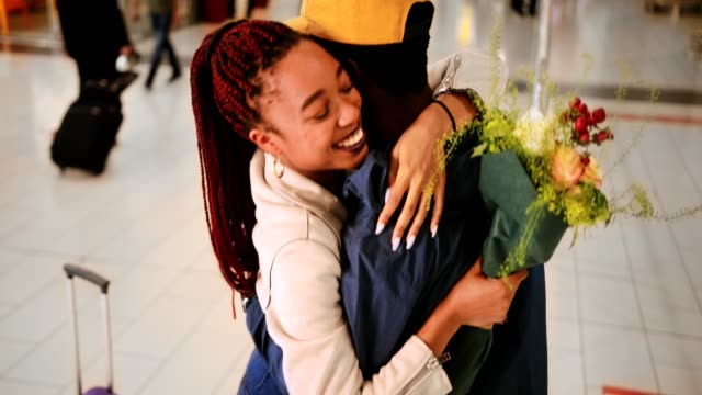 Junge-Menschen-treffen-und-nach-dem-Flug-am-Flughafen-umarmen