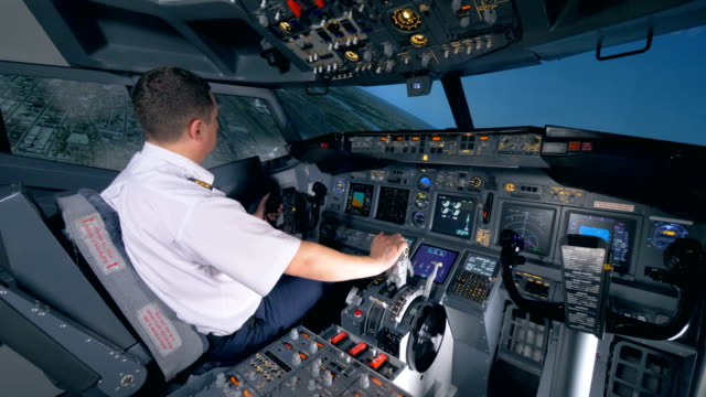 Un-aviador-se-sienta-en-un-simulador-de-vuelo-y-convierte-de-un-plano-a-la-izquierda.-4K.