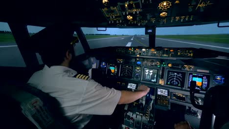 Two-pilots-are-in-a-cockpit,-while-a-plane-goes-on-a-runway.-4K.