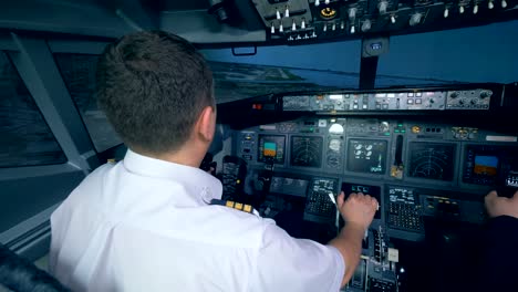 Two-airmen-in-flight-simulator,-holding-helms-in-a-cockpit.-4K.