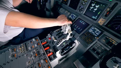 Pilot-holds-his-hand-on-a-lever-in-a-cockpit,-close-up.-4K.