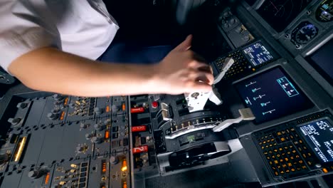 One-pilot-holds-his-hand-on-a-plane-lever-in-a-flight-simulator.-4K.