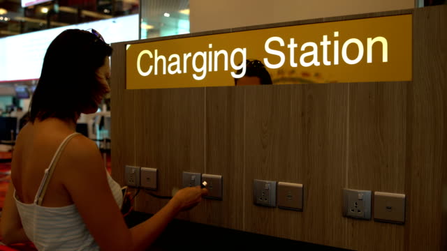A-woman-is-charging-a-smartphone-on-the-charging-station-at-the-airport