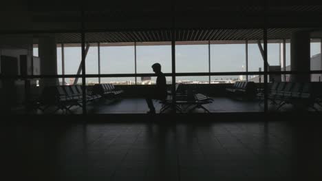 Silhouette-der-Passagier-sitzt-in-einem-Flughafen,-Sitzecke
