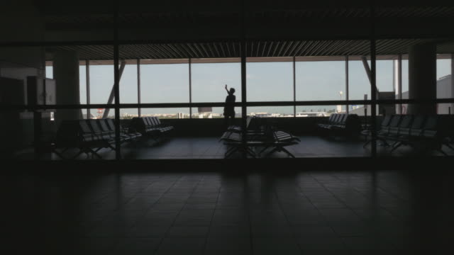 Silhouette-der-Passagier-warten-im-Flughafen-Sitzecke